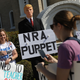 A mannequin is seen with a President Donald Trump mask and a sign that reads “NRA Puppet” as people gather, as close as they can to where President Donald Trump is staying at his Mar-a-Lago club, for a March for Our Lives event calling for gun control March 24, 2018, in West Palm Beach, Fla.